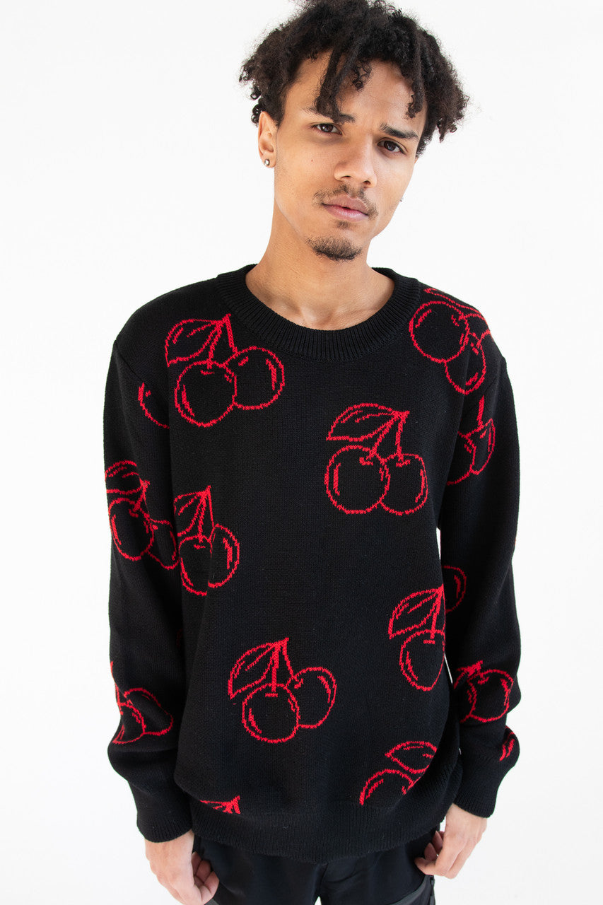 Man wearing black sweater with red cherry pattern