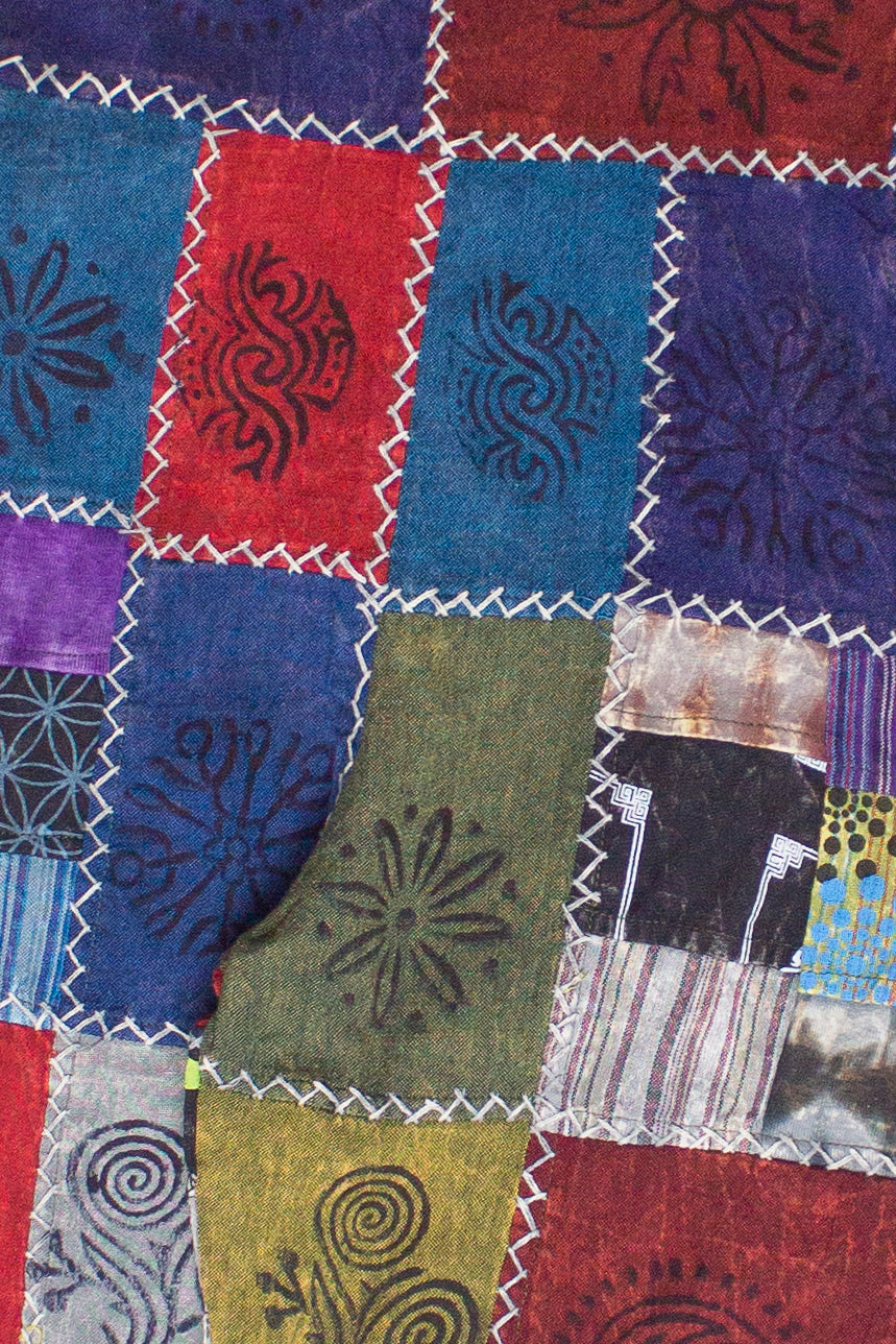 Close-up of handmade patchwork overalls with colorful fabric squares and decorative stitching details