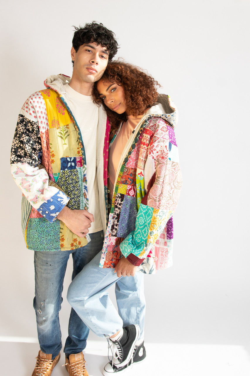Man and woman standing together both wearing colorful patchwork jackets