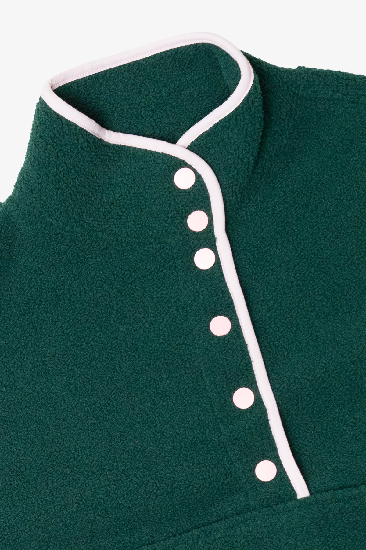 Close-up of a dark green fleece pullover with pink snap buttons and matching collar trim