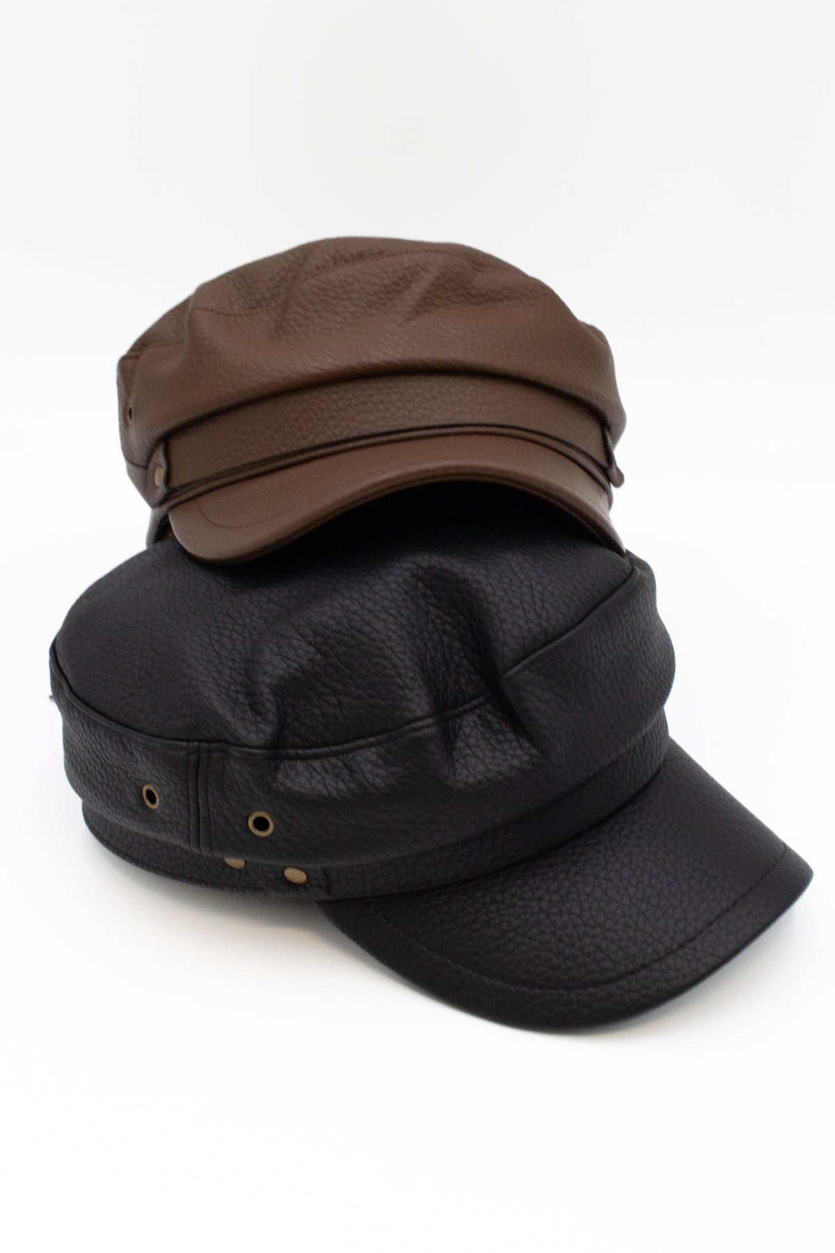Brown and black textured leather fiddler caps stacked together
