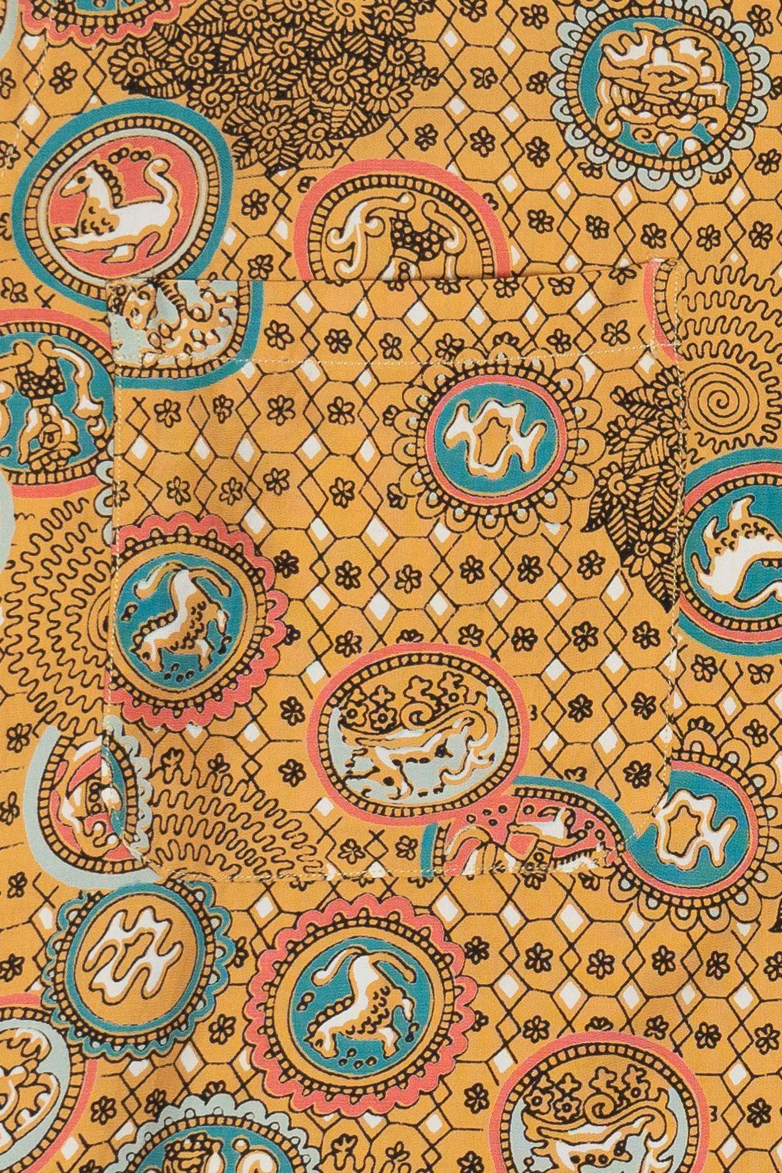 Decorative fabric with intricate patterns and animal illustrations on a yellow background