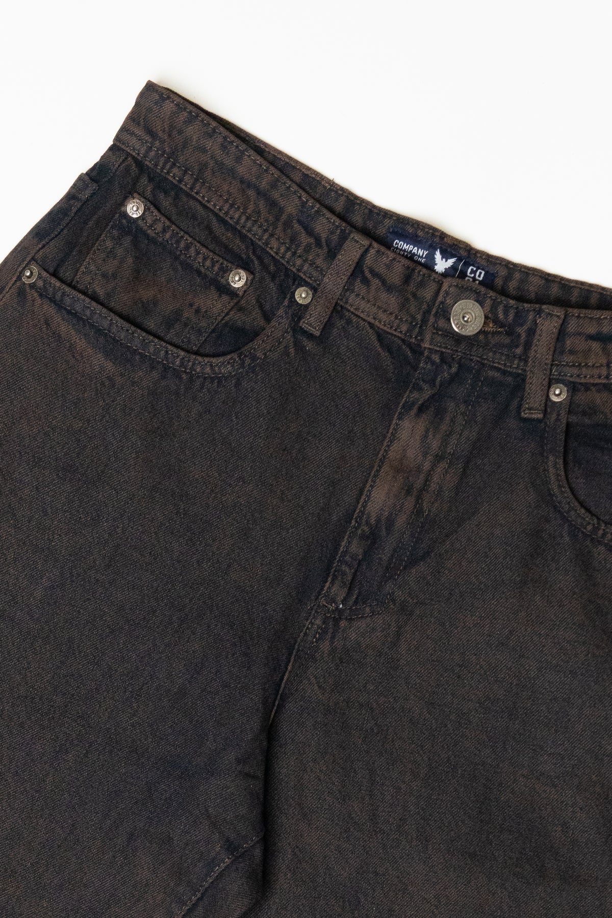 Washed dark brown denim jeans showing waistband, front pockets, and Company label