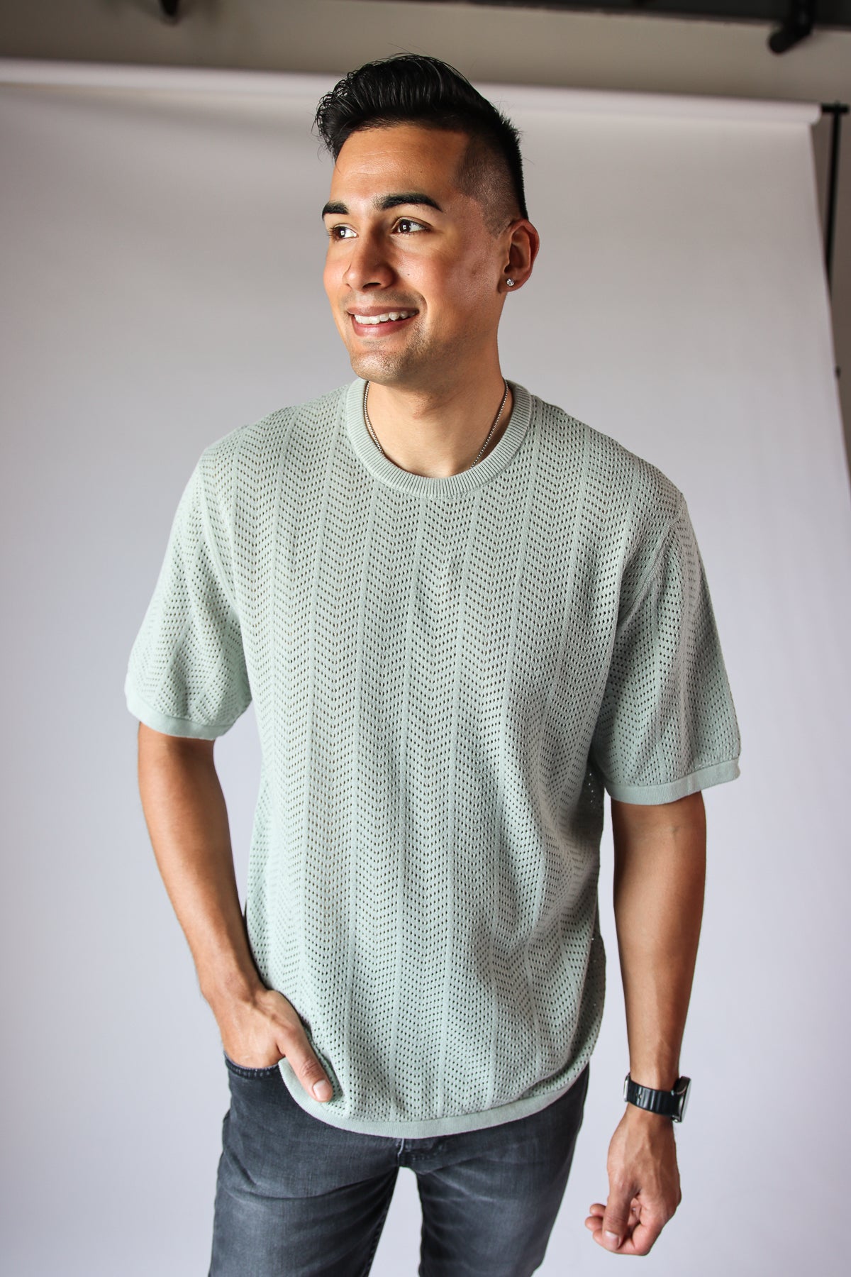 Man wearing light green Chevron Open Weave Tee with short sleeves and round neckline, standing against plain background