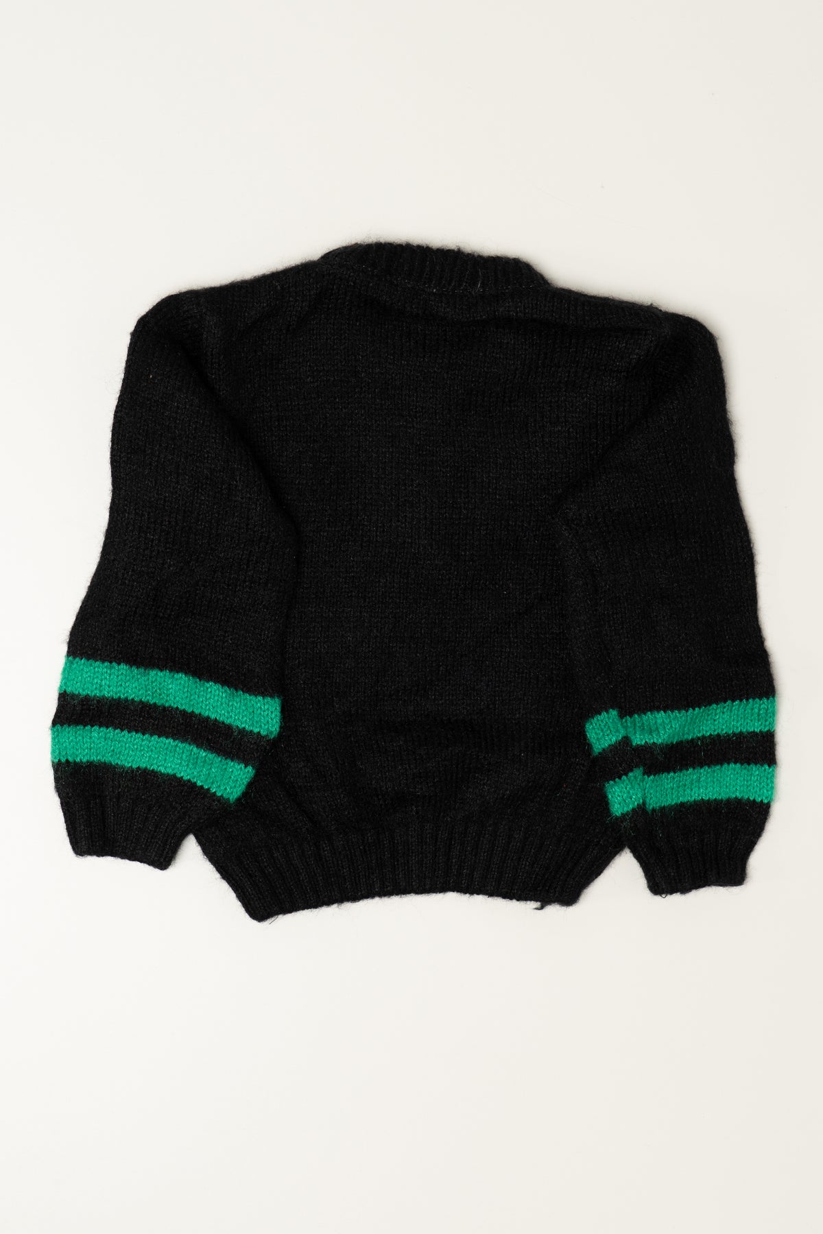 Back view of a black knit sweater with two green stripes on the sleeves