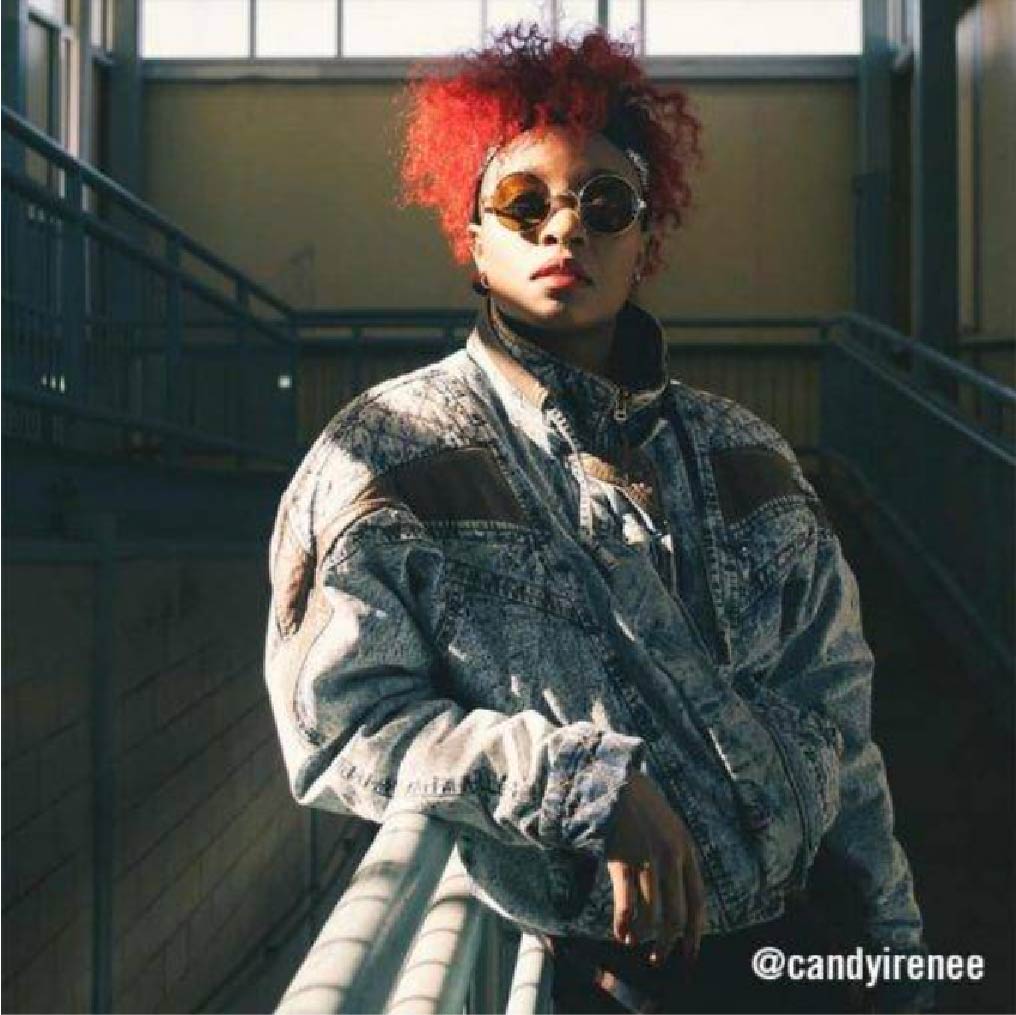@candyirenee wearing oversized acid-wash denim jacket with round sunglasses–grunge 90's look.