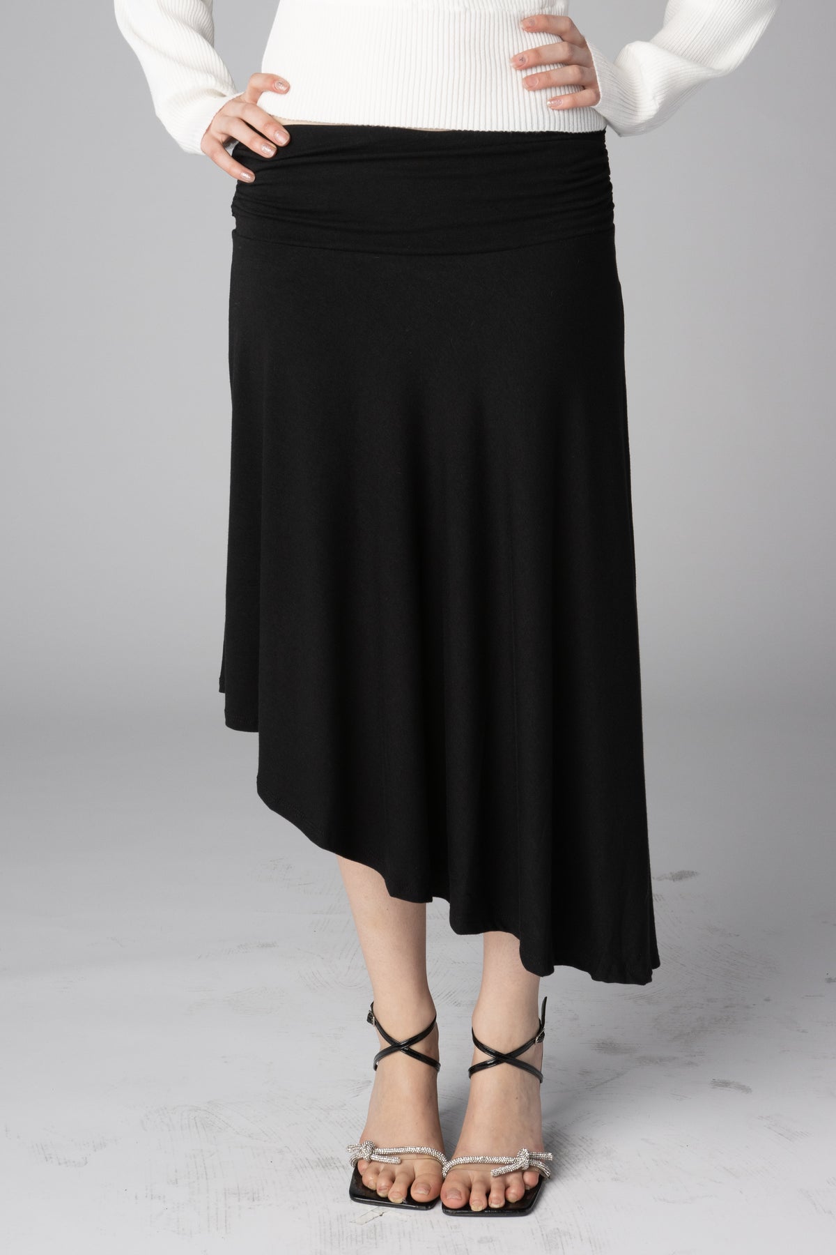 Black midi skirt with a gathered waist and an asymmetrical hem