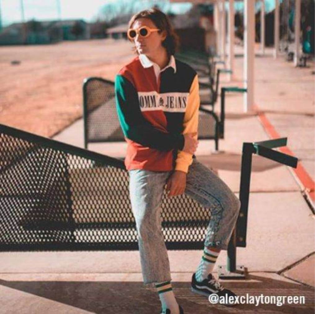 @alexclaytongreen in color-block ruby sweatshirt and light-wash jeans, soaking up the sun.