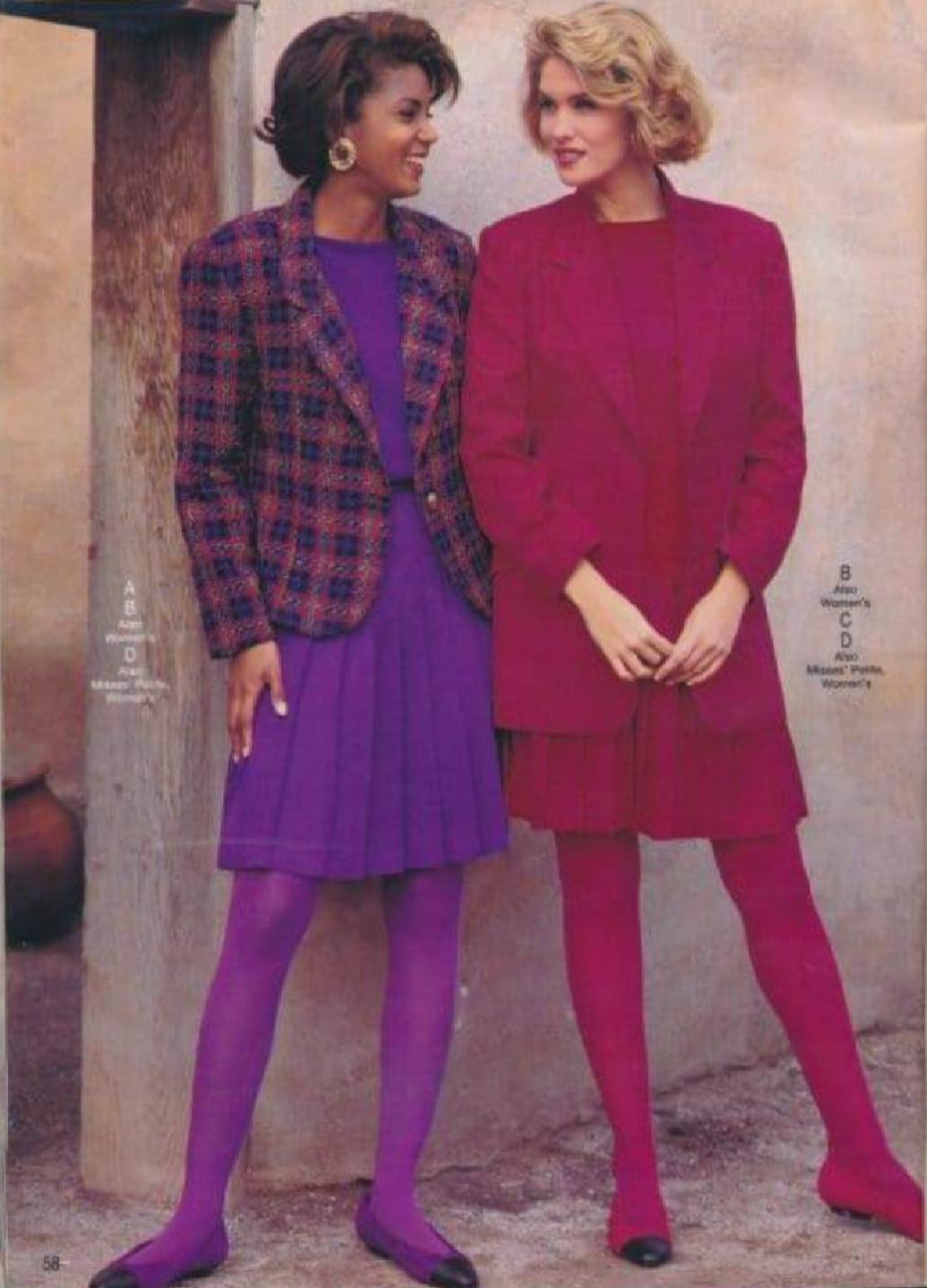 Authentic vintage 90's catalog image of two female models wearing monochromatic outfits consisting of tights, pleated skirts, tops, and blazers.