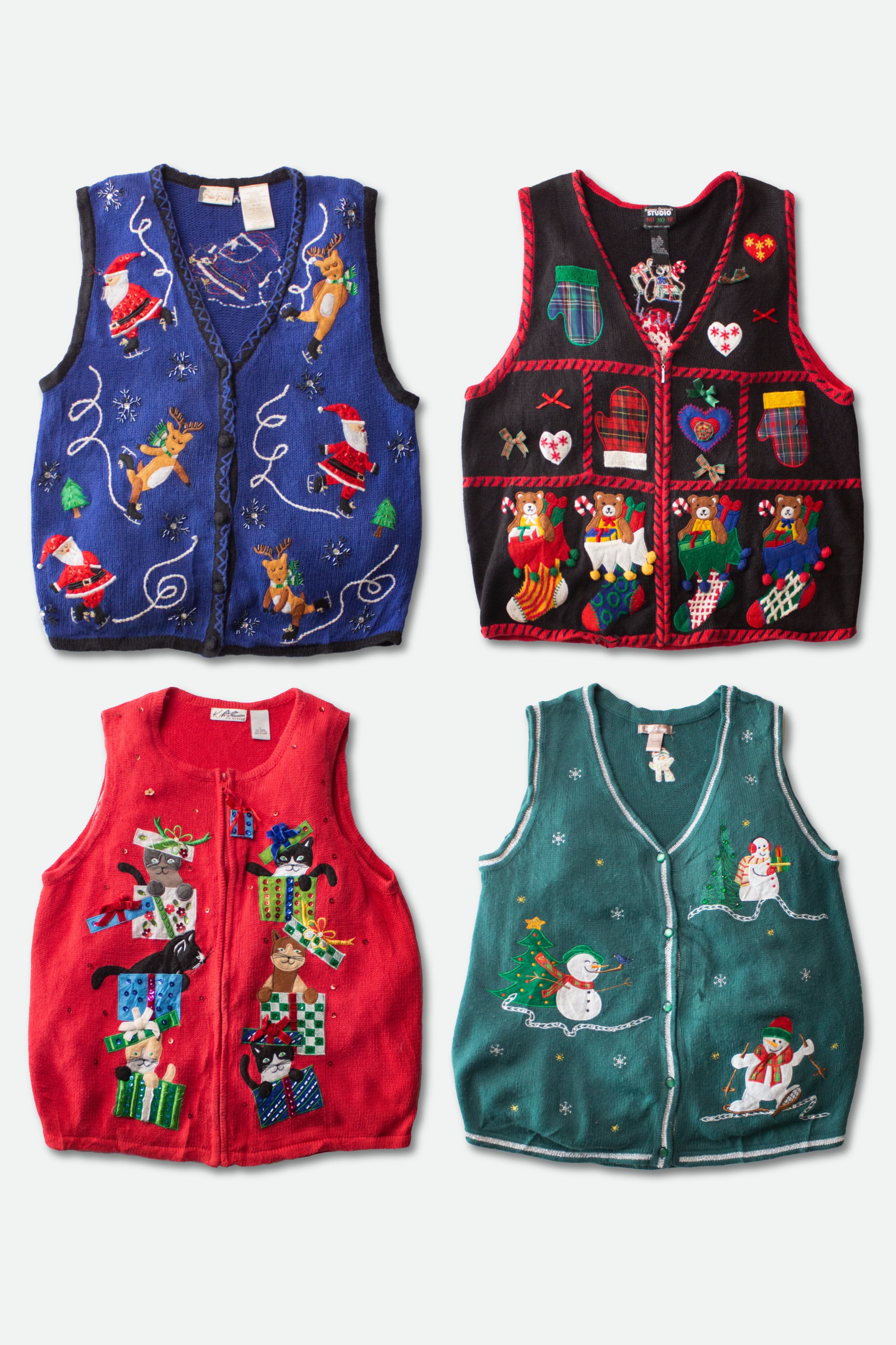 Four vintage ugly Christmas sweater vests with colorful holiday-themed designs laid flat on white background.
