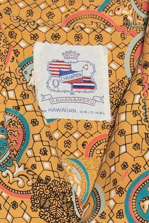 Patterned fabric with a Kahanamoku label on an orange background