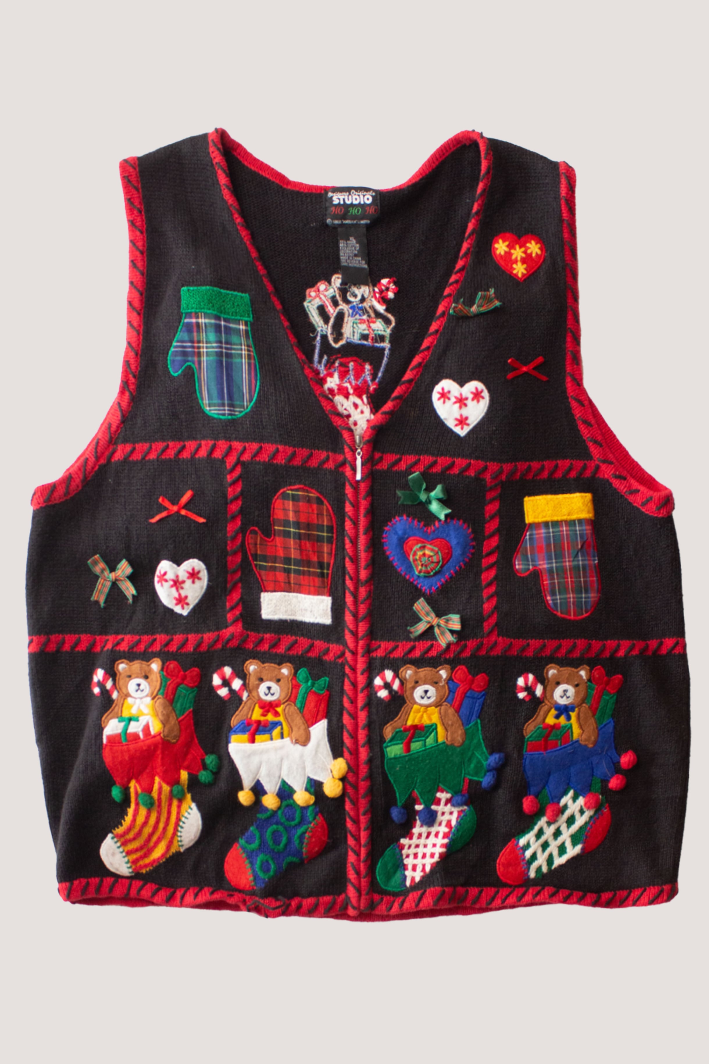Vintage black Christmas sweater vest with colorful holiday-themed appliques including mittens, hearts, and teddy bears in stockings