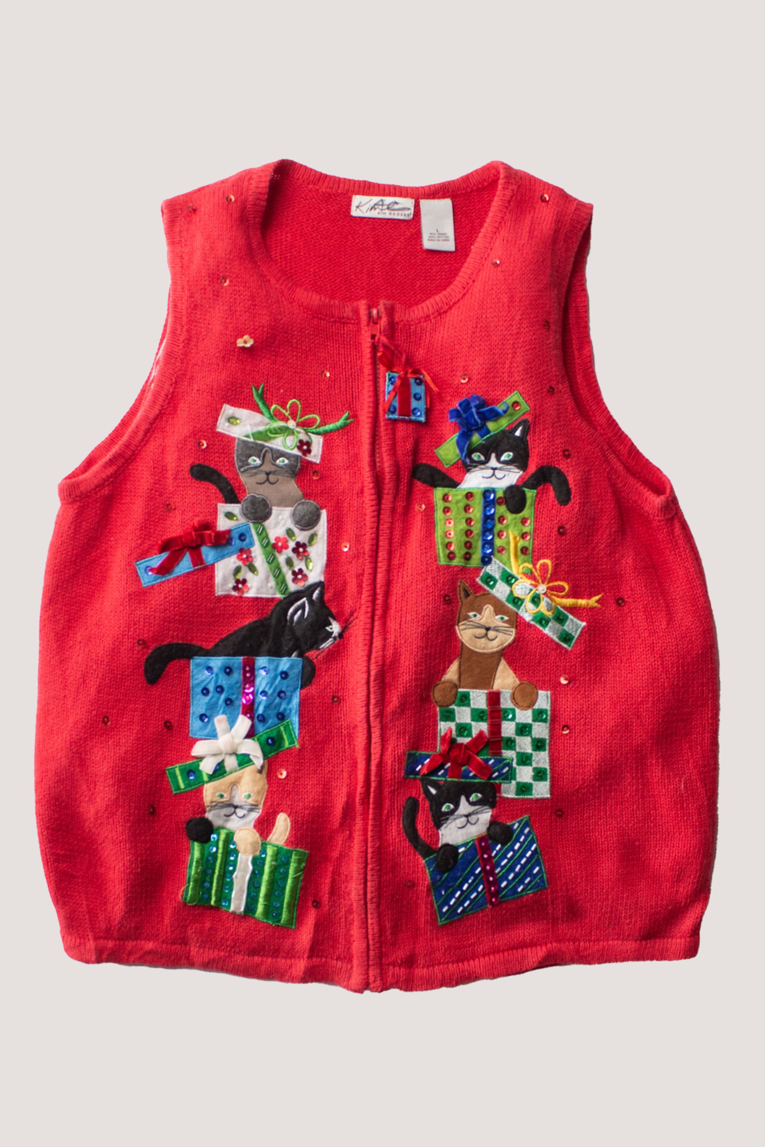 Red vintage ugly Christmas sweater vest with playful cats popping out of colorful gift boxes and decorative embellishments