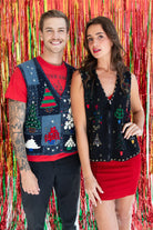 Man and woman wearing vintage ugly Christmas sweater vests with festive tree designs in front of red tinsel backdrop