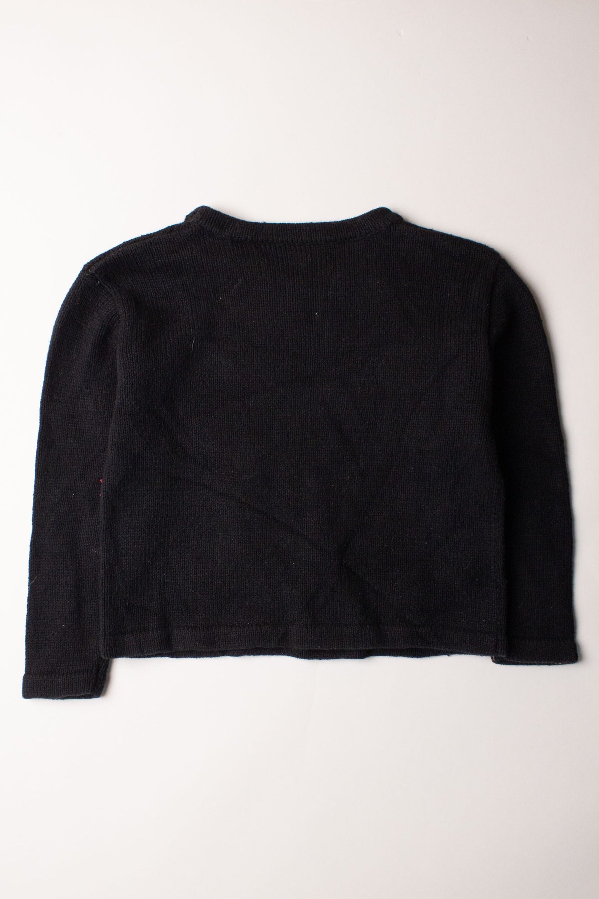 Kids black ugly Christmas pullover sweater laid flat showing the back side on white background