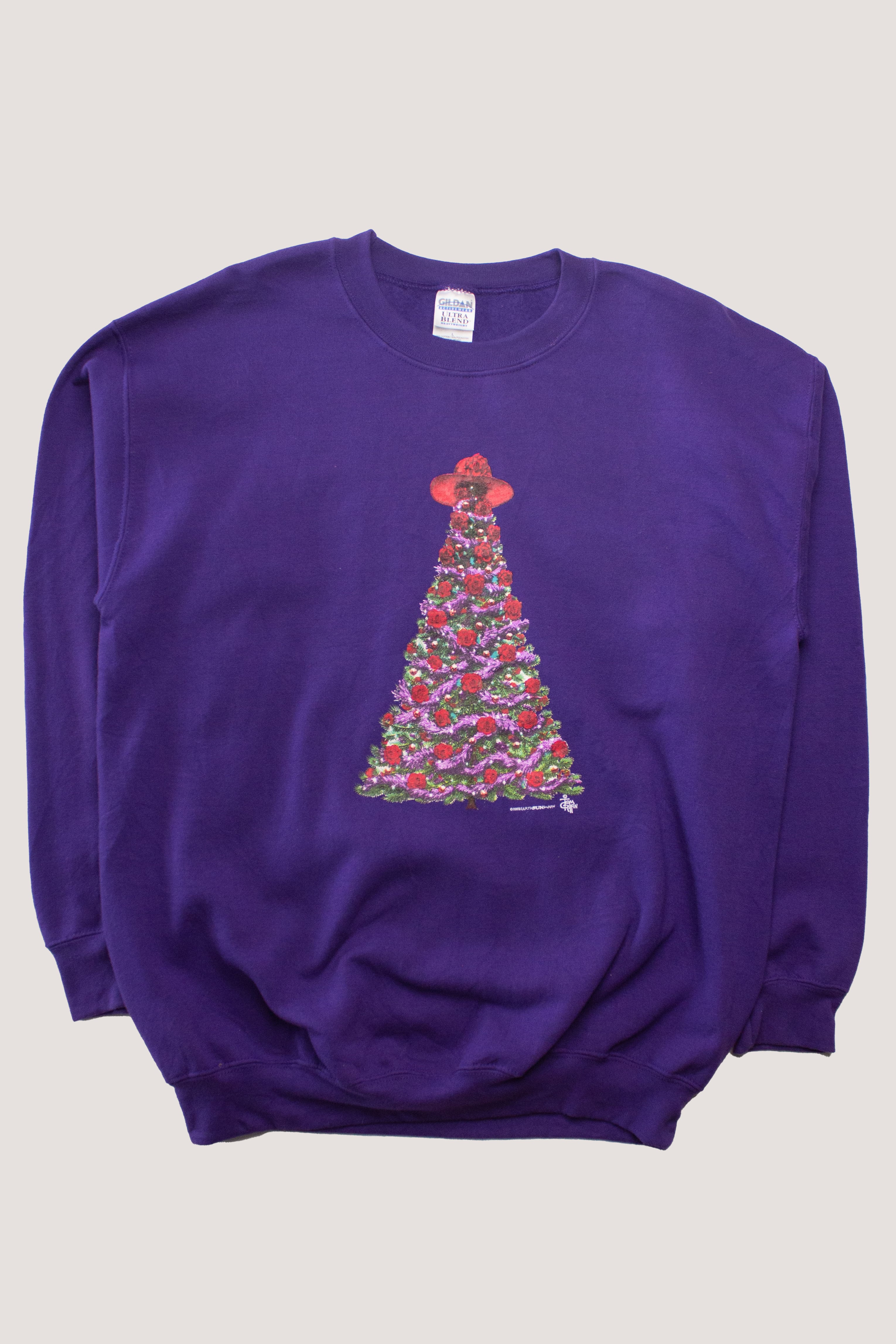Purple vintage Christmas sweatshirt with decorated tree wearing a red hat, women's sizing, folded flat on light background