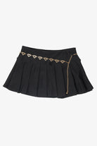 Black pleated mini skirt with a gold heart chain belt