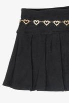 Black pleated mini skirt with a gold rhinestone heart chain belt detail