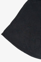 Close-up detail of the curved hemline on a black flared jersey skirt