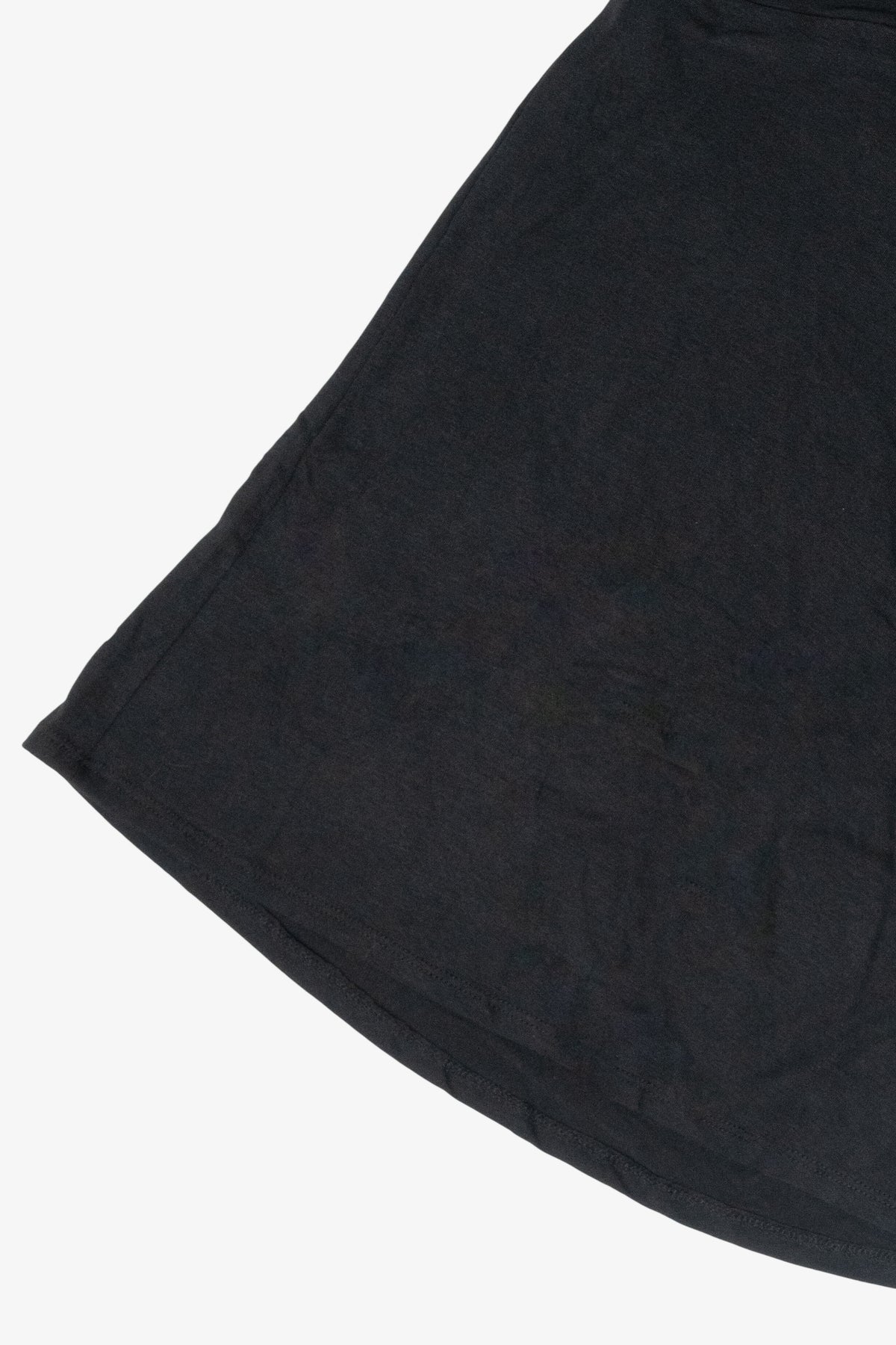 Close-up detail of the curved hemline on a black flared jersey skirt