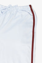 Close-up of white drawstring shorts featuring a burgundy side stripe