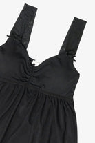 Black sleeveless babydoll top with ruched sweetheart bust and wide sheer straps with bows
