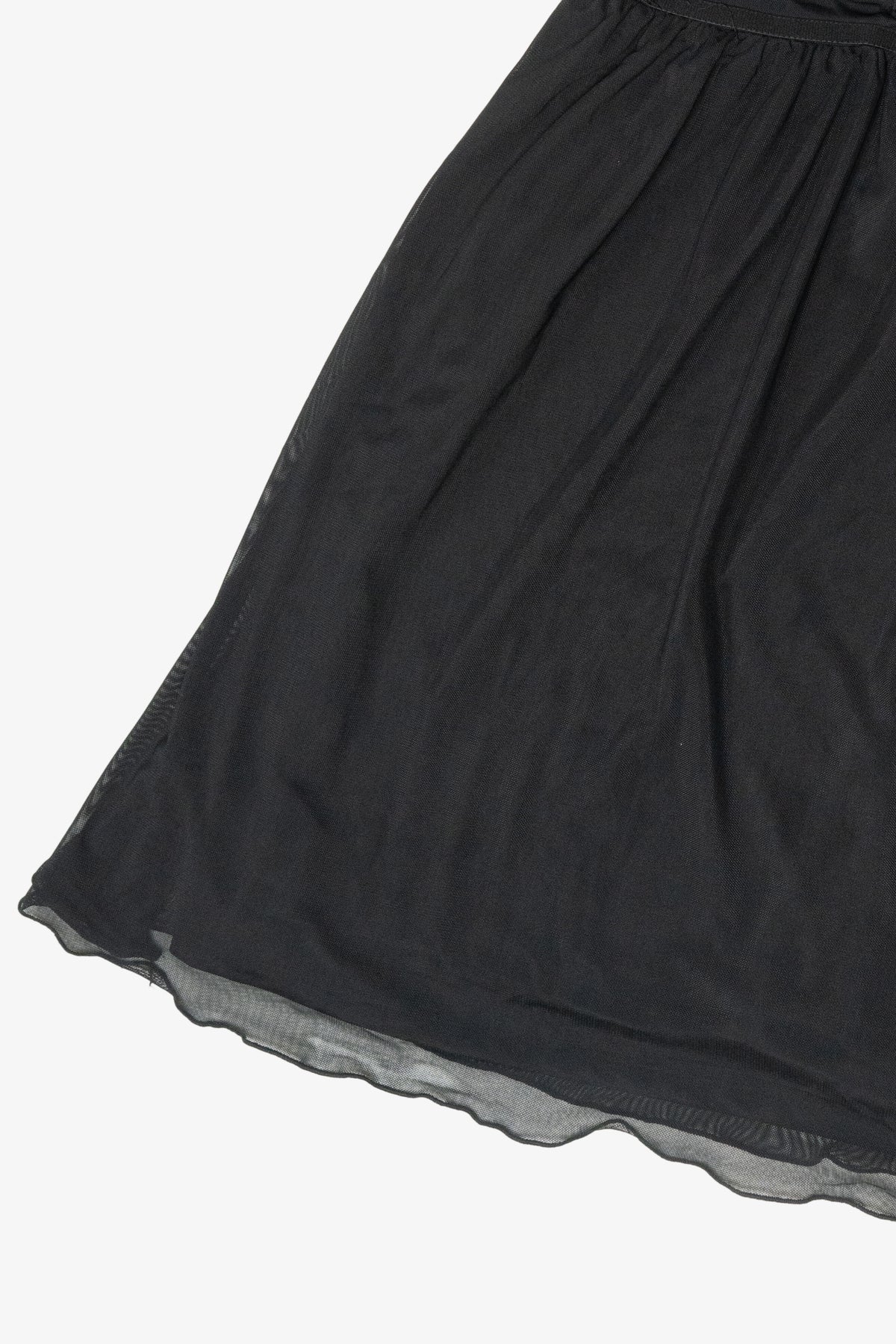 Close-up of the gathered hem on a black sheer mesh dress