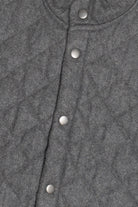 Close-up of a gray textured fabric with silver buttons