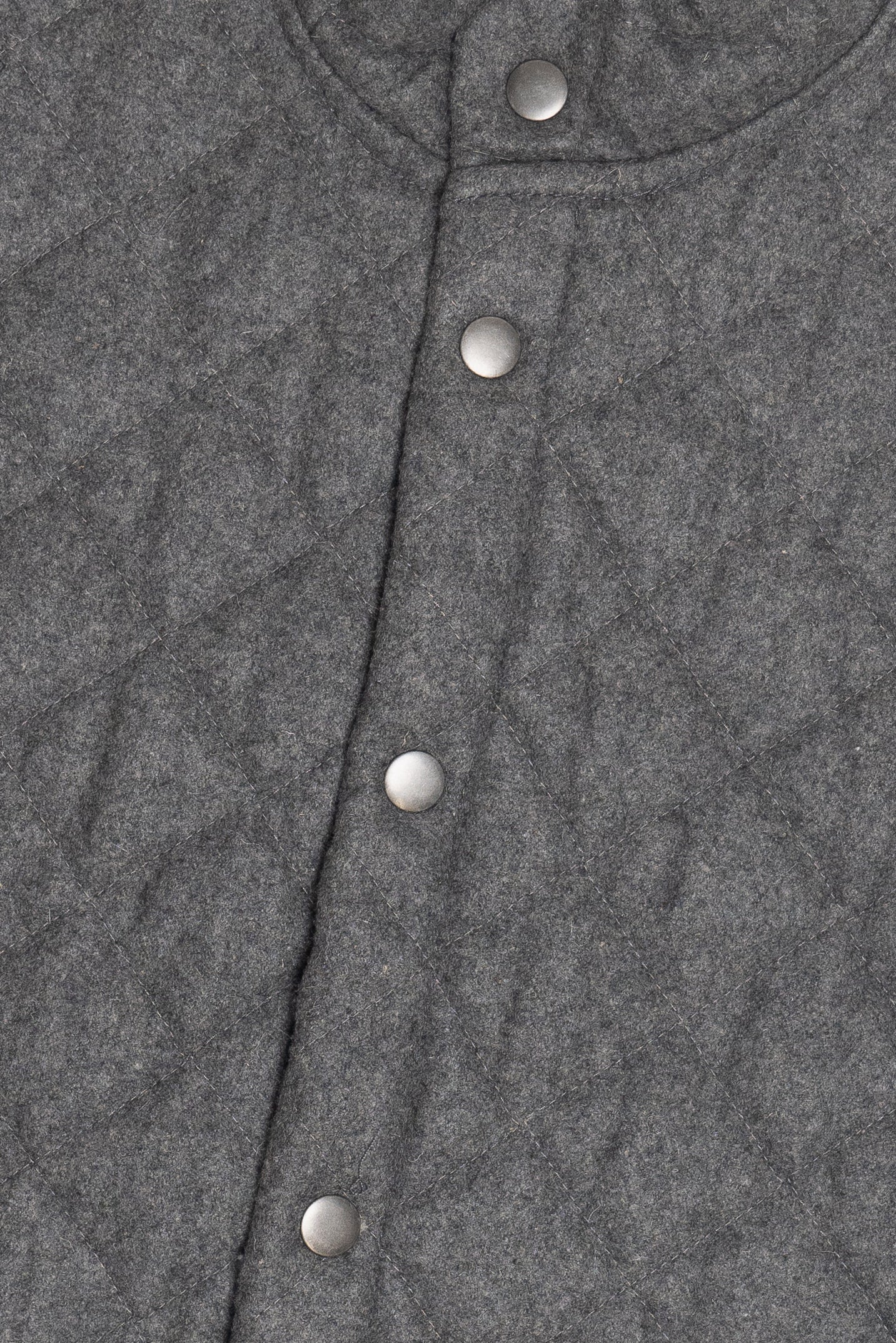 Close-up of a gray textured fabric with silver buttons