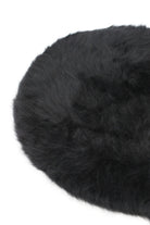 Round black fluffy faux fur cushion on a white background