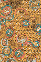Decorative fabric with intricate patterns and animal illustrations on a yellow background