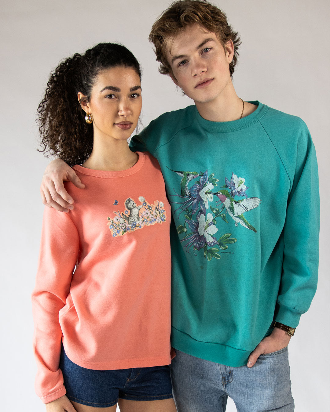 Models wearing bright vintage sweatshirts with graphics