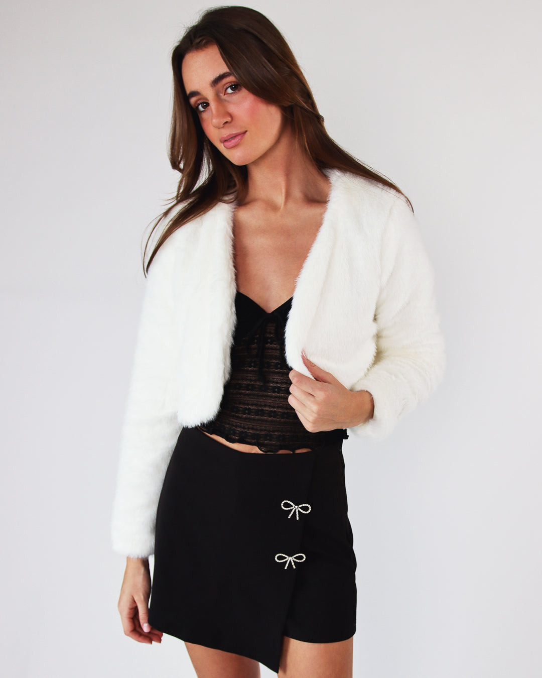 model wearing faux fur bolero and rhinestone bow skort