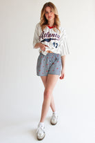 Young woman wearing printed gingham boxer shorts with elastic waistband and a casual baseball tee