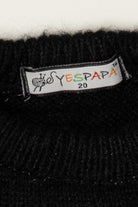 White brand label reading YESPAPA 20 sewn into the collar of a black knit sweater