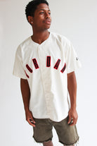 Man wearing vintage white Nike Jordan button-up basketball shirt with red lettering and olive green shorts