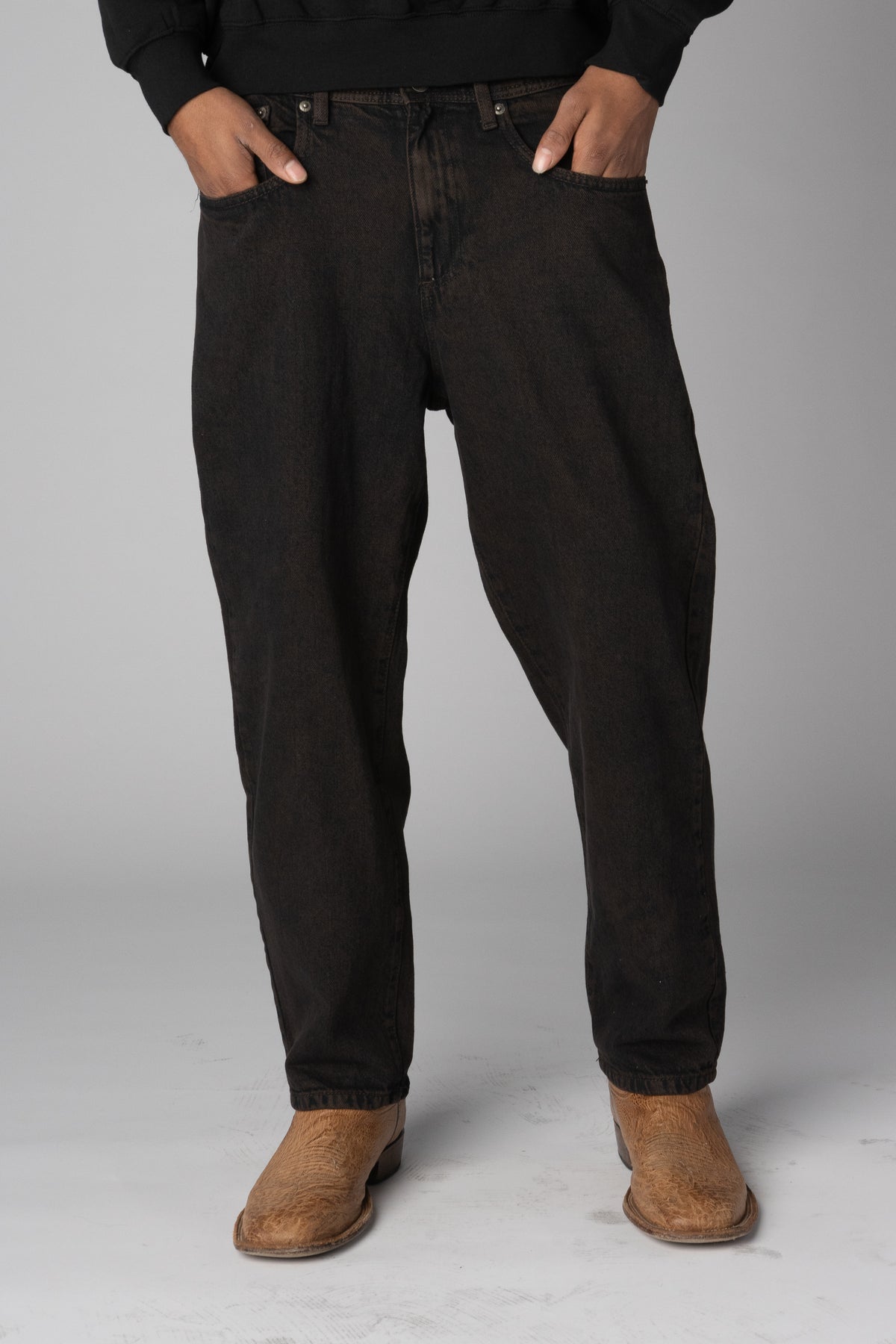 Men's relaxed fit washed black denim jeans paired with tan leather boots