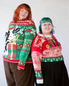 Two people wearing festive holiday sweaters, one with a cow and present and one reading Merry Christmas