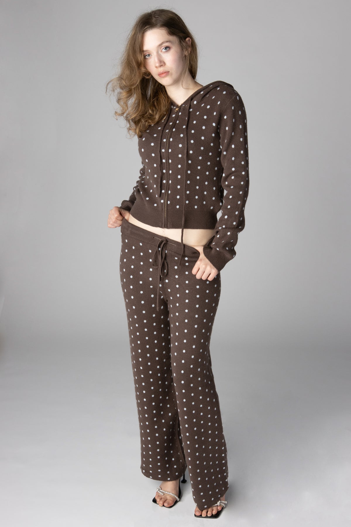 Woman modeling a brown polka dot knit zip-up hoodie and matching wide-leg lounge pants