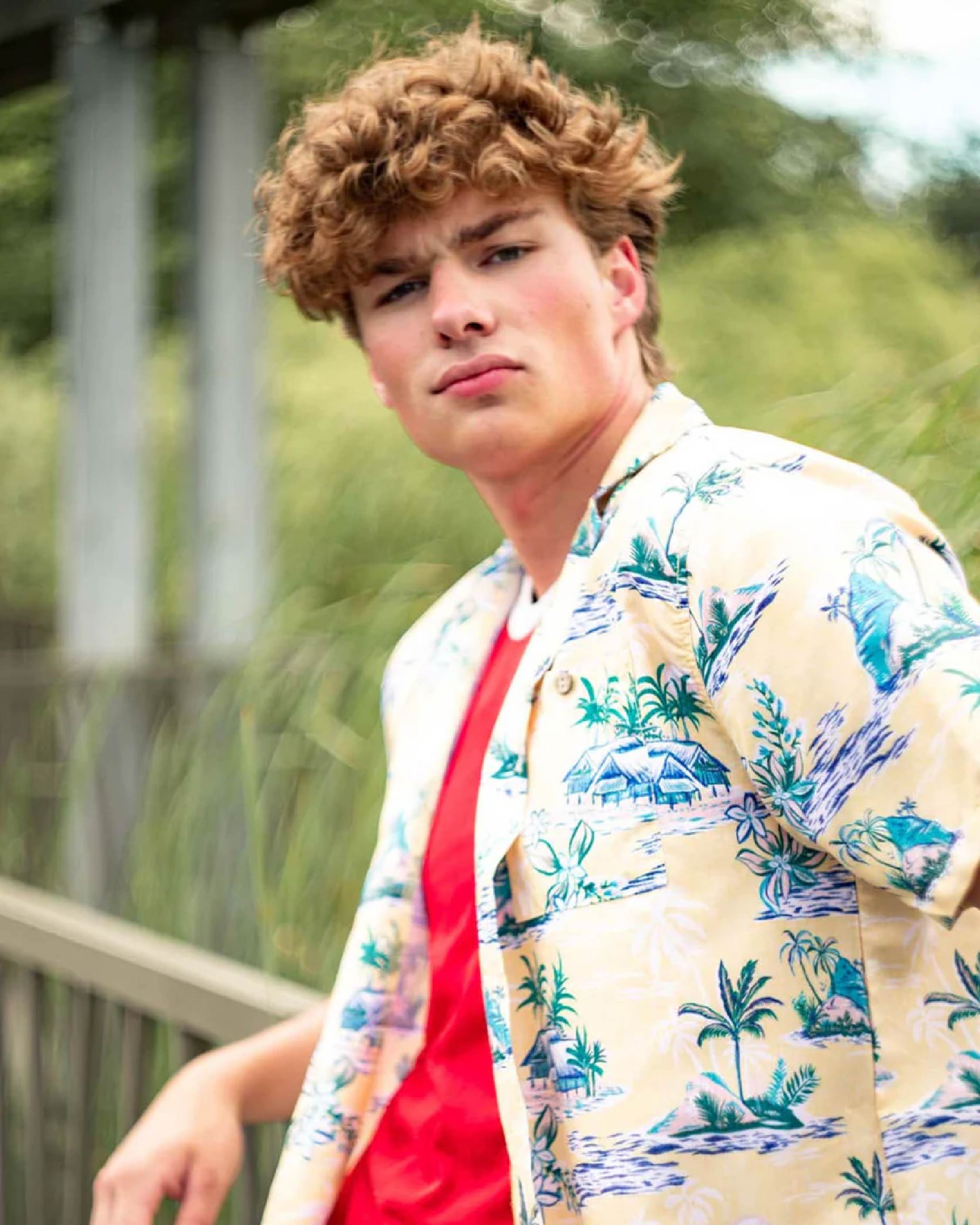 male model outside wearing a yellow hawaiian shirt