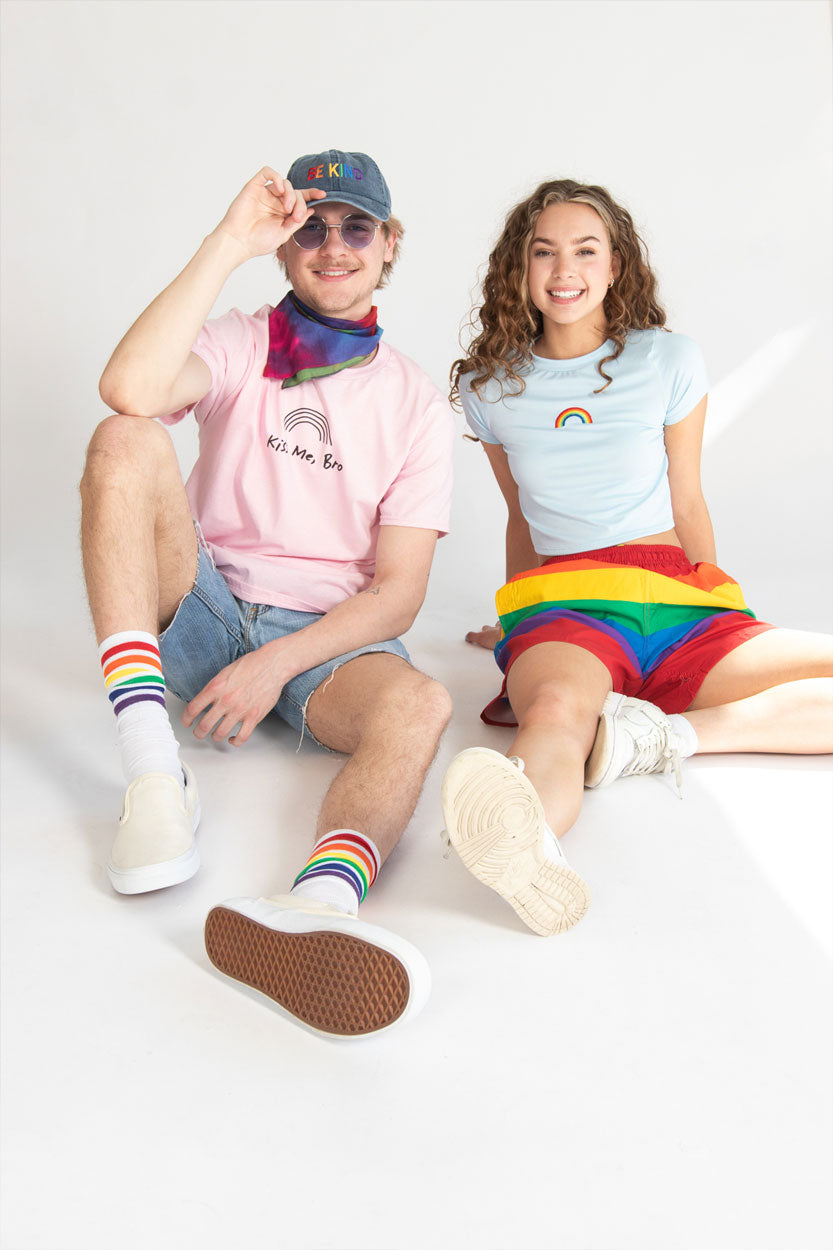 Two models wearing our Pride collection of rainbow tees, socks and shorts