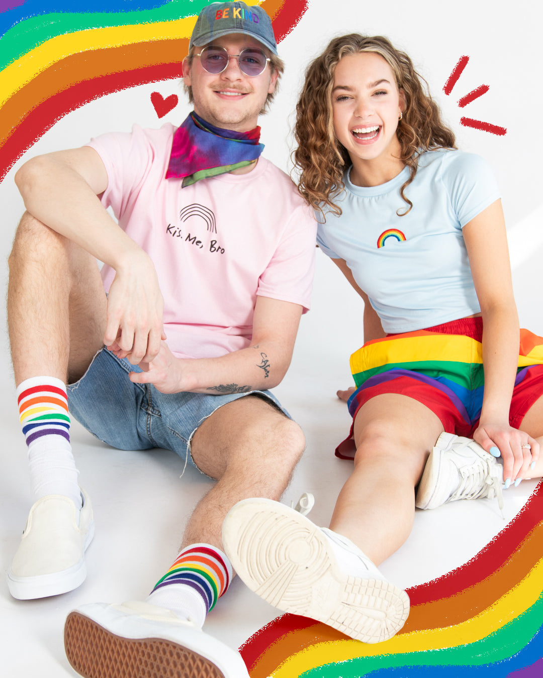 Two models wearing rainbow pride merchandise surrounded by rainbow drawing. 