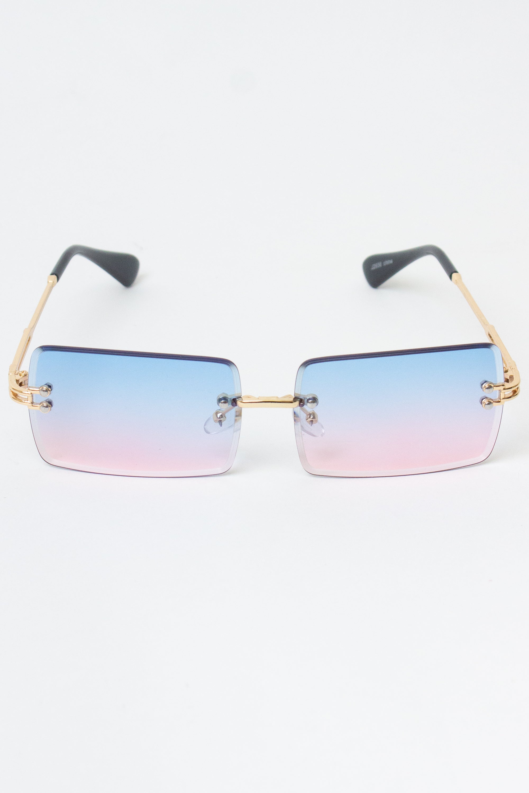 Rimless rectangle sunglasses with gradient blue to pink lenses and gold temples offering UV protection.