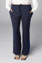 Navy blue wide-leg track pants with bright blue side stripes and drawstring waist