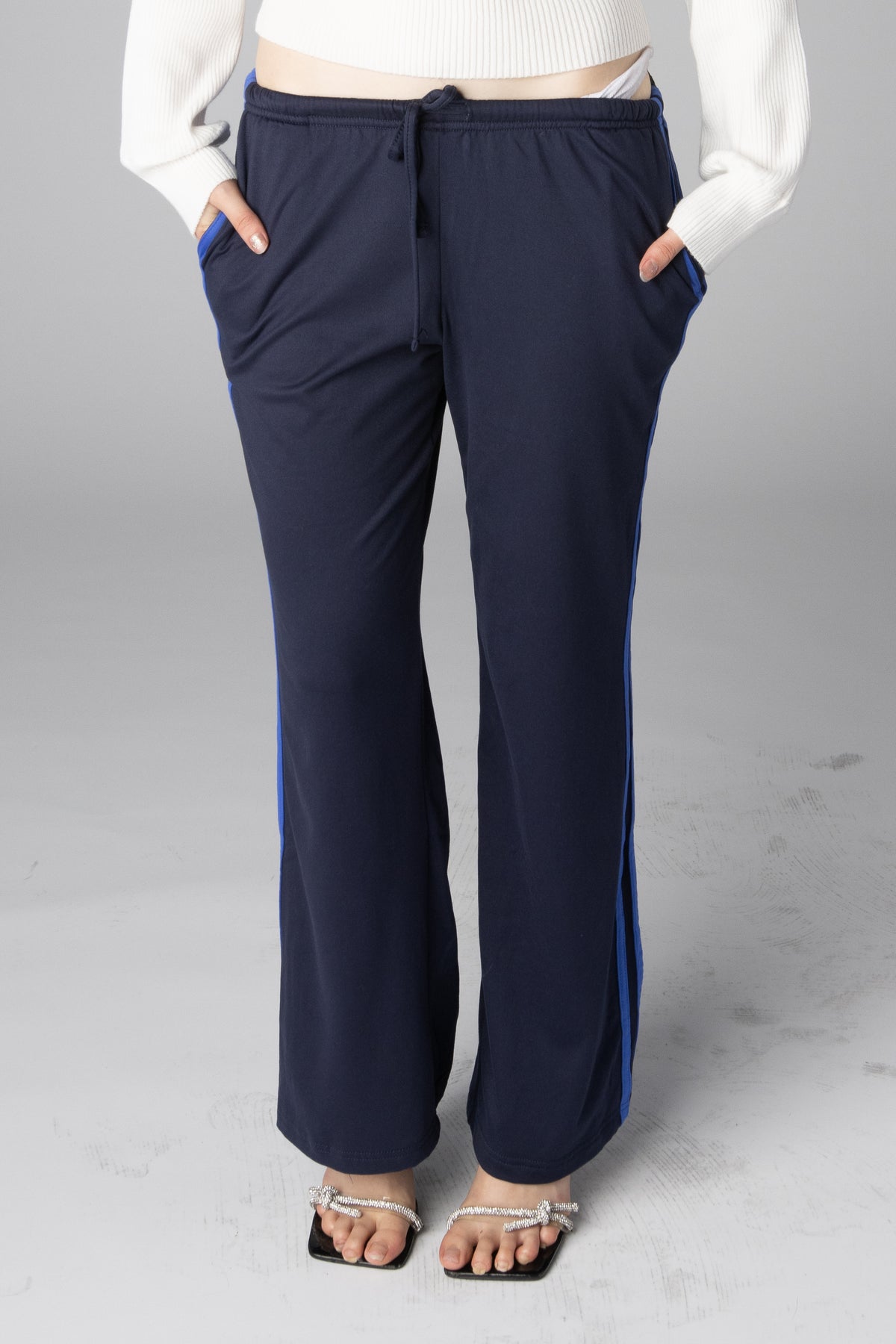 Navy blue wide-leg track pants with bright blue side stripes and drawstring waist