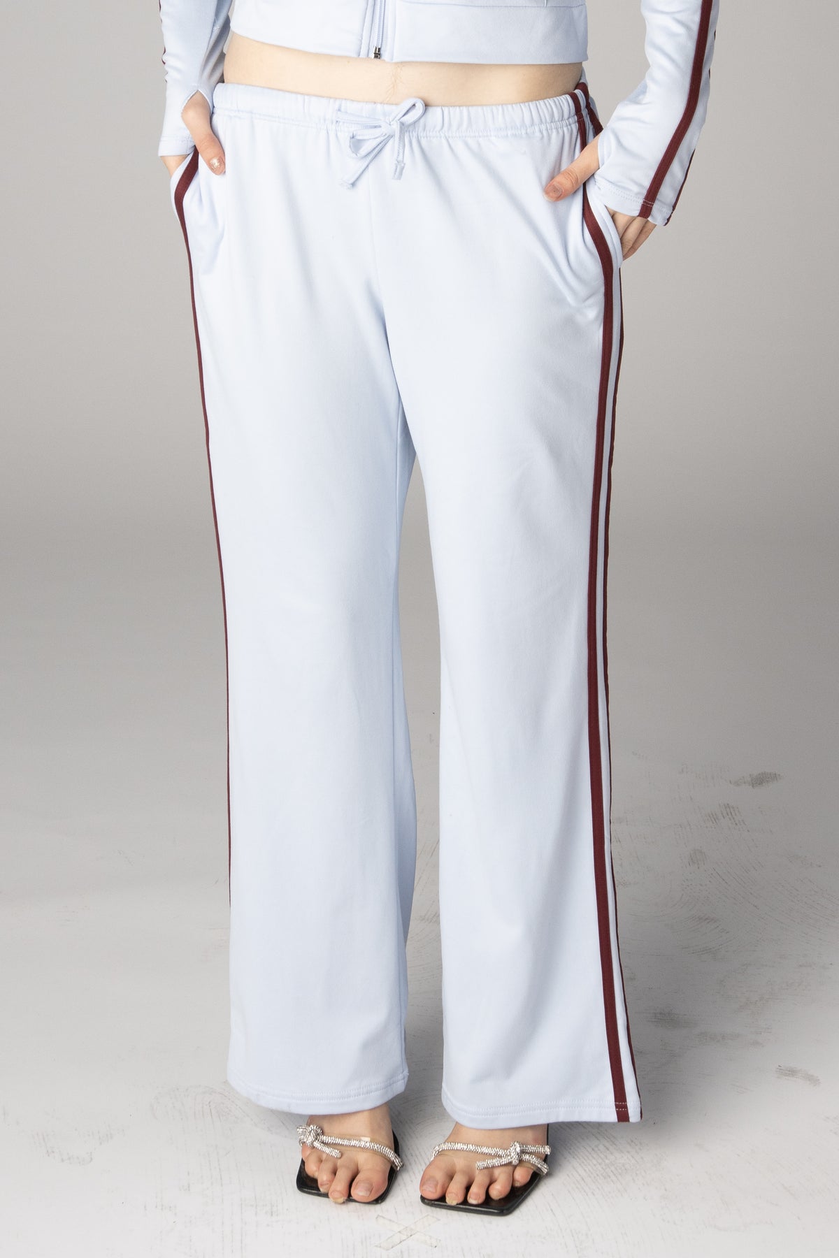 Light blue wide-leg sweatpants with burgundy side stripes and drawstring waist