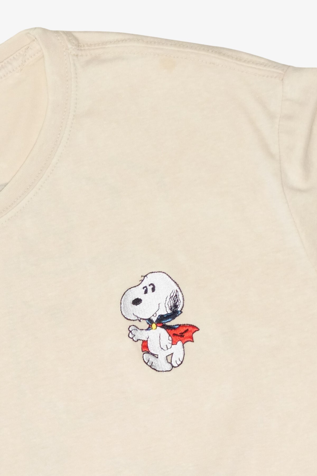 Cream t-shirt featuring an embroidered vampire Snoopy wearing a cape