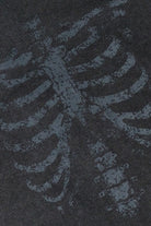 Black waffle-knit fabric with a faded grey skeleton ribcage graphic print