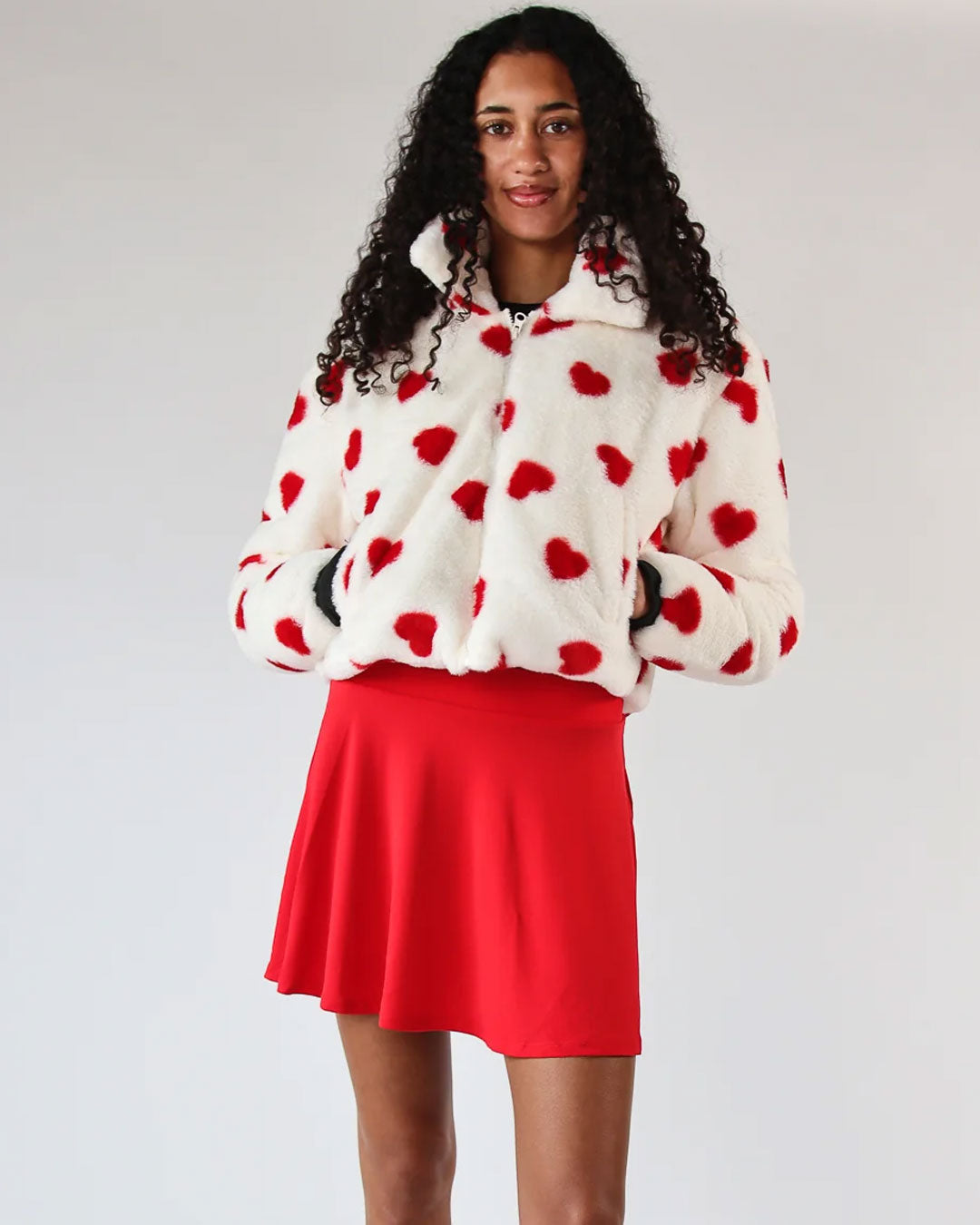 Model wearing a faux fur jacket with red hearts from our Valentine collection.