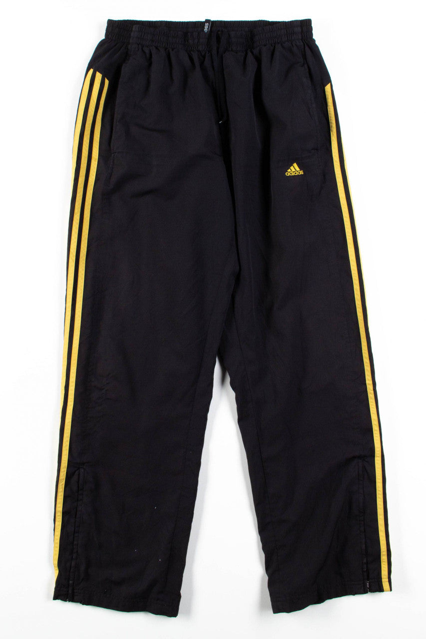 black adidas pants with gold stripes